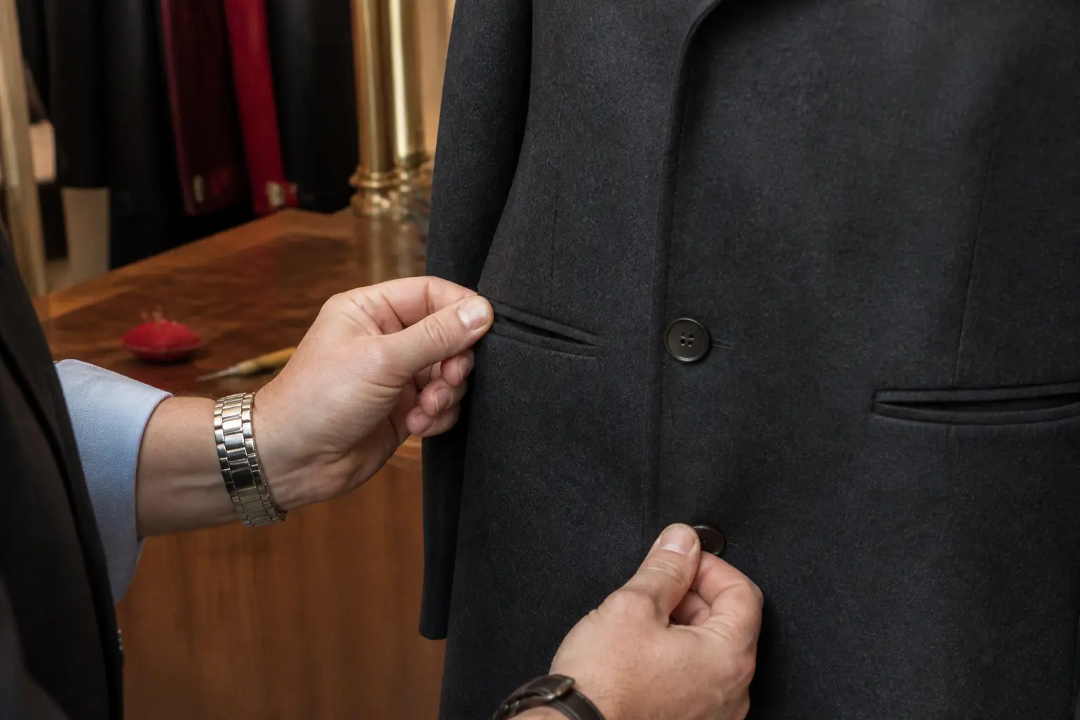 Faut il découdre les poches des manteaux neufs : tailleur testant la poche d’un manteau en laine sombre